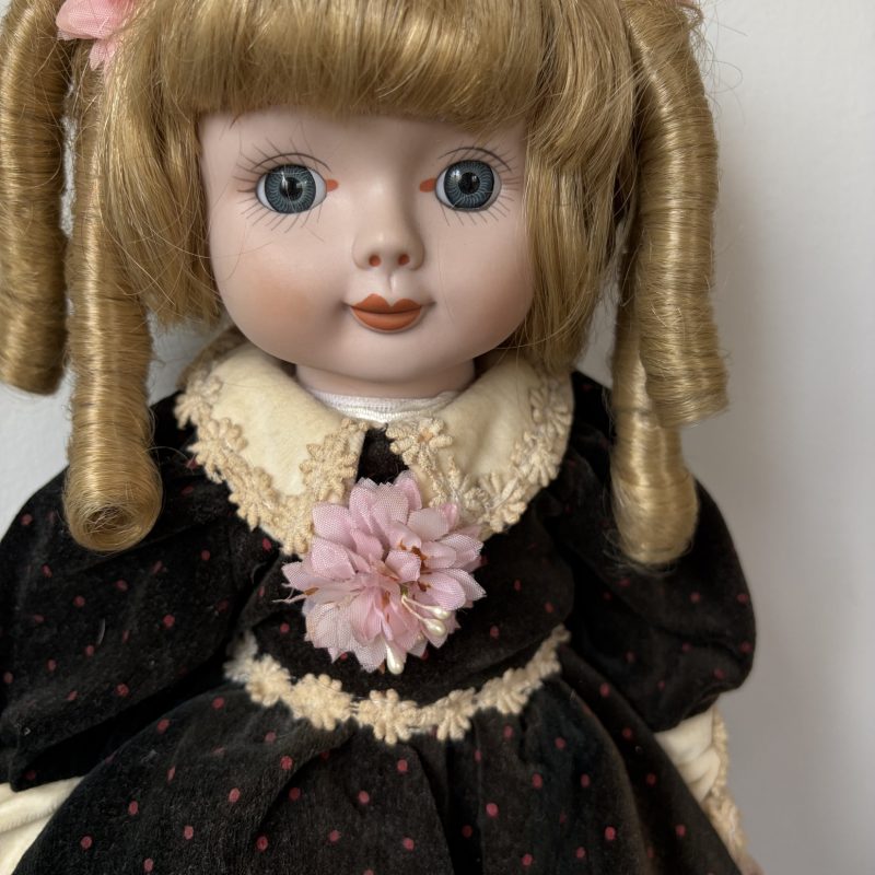 Vintage Porcelain Doll with Blonde Curls and Black Dress