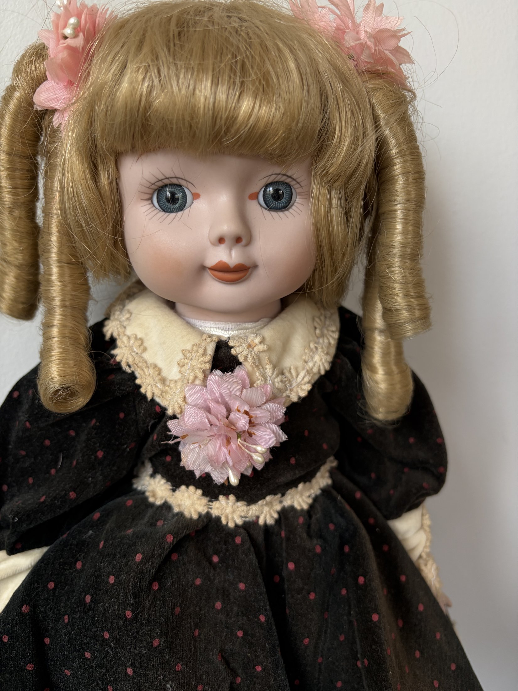 Vintage Porcelain Doll with Blonde Curls and Black Dress